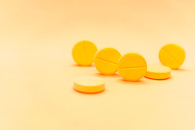 Close-up of yellow pills against pink background