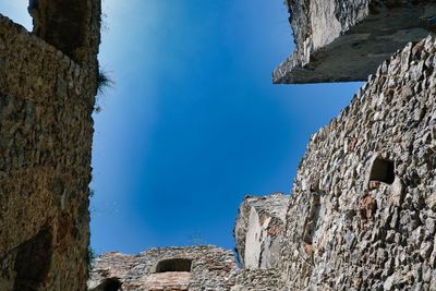 Low angle view of old building against clear blue sky