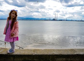 Full length of girl standing by sea against sky