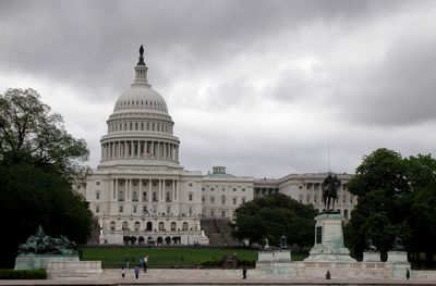 Low angle view of capitol building against cloudy sky