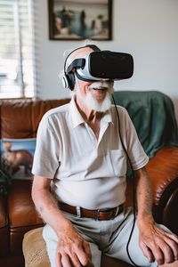 Amazed senior grandfather in virtual headset glasses watching 3d video at home. ai generated