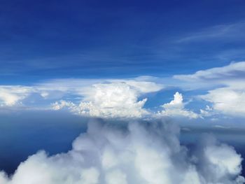 Low angle view of sunlight streaming through clouds