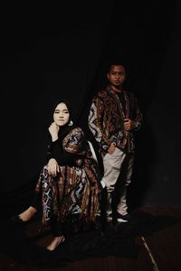 Portrait of a young couple sitting in the dark