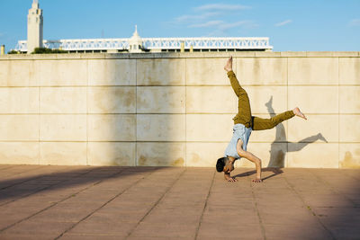 Rear view of people walking on floor against sky