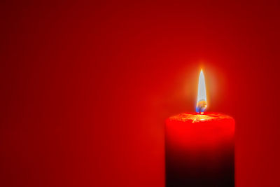 Close-up of lit candle in darkroom