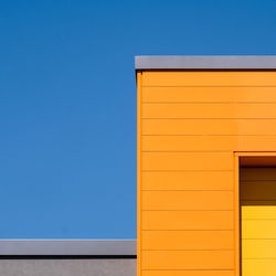 Low angle view of yellow building against clear sky