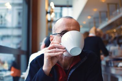 Portrait of man holding ice cream in restaurant