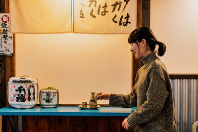 Side view of a young woman against the wall