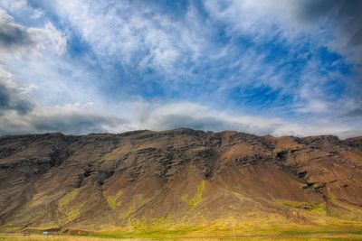 Scenic view of mountains against cloudy sky