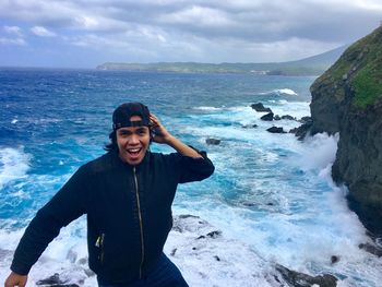 Portrait of young man in sea against sky