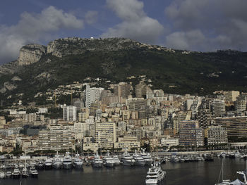 Aerial view of city by sea against sky