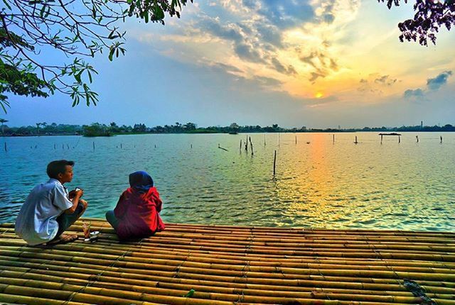 water, sky, lifestyles, leisure activity, tranquil scene, sitting, lake, tranquility, scenics, beauty in nature, relaxation, tree, rear view, person, cloud - sky, nature, men, pier, vacations