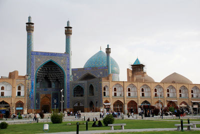 Group of people in front of historic building against sky