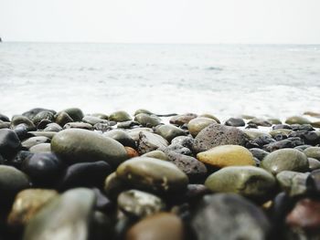 Close-up of pebbles on beach against clear sky