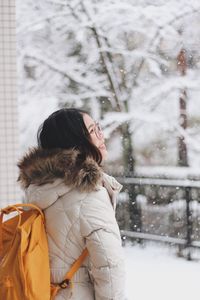 Woman standing on snow covered tree