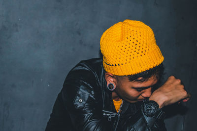 Portrait of man wearing hat against wall during winter