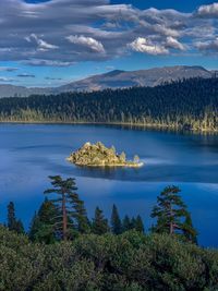 Scenic view of lake by trees against sky