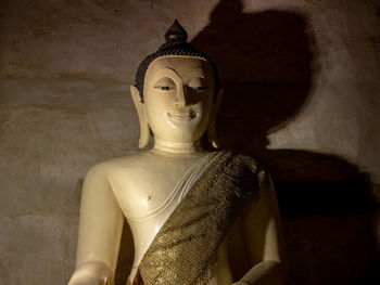 Statue of buddha against wall