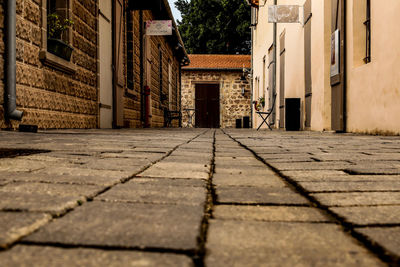Surface level of cobblestone street amidst buildings