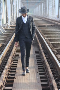 Full length of man walking on railroad station