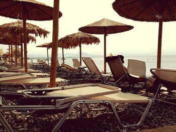 Chairs on beach umbrellas by sea