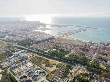 High angle view of cityscape by sea against sky