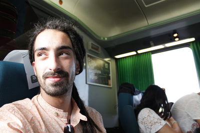 Close-up of smiling young man in train