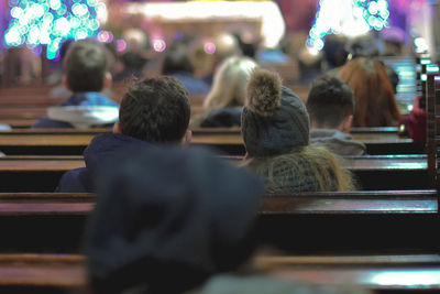 Rear view of people sitting on pews in church