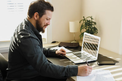 Side view of man working at home