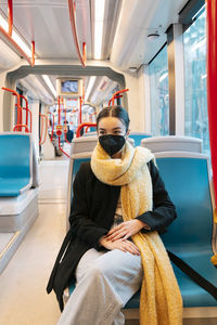 Teenage girl wearing protective face mask in bus