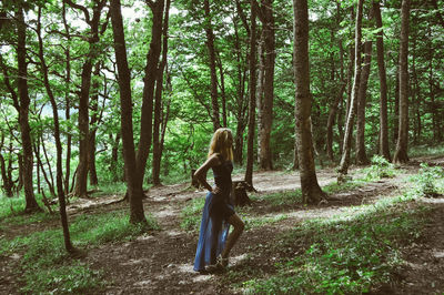 Full length of young standing woman in forest