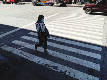 Full length of man crossing road