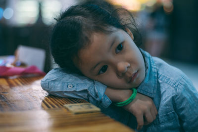 Close-up thoughtful girl leaning on table at home