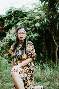 Portrait of beautiful young woman standing on field