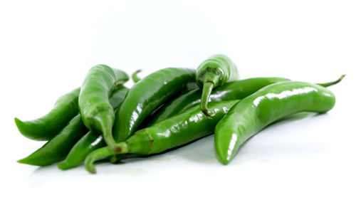 Close-up of green chili pepper against white background