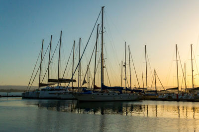 Sailboats in marina at sunset