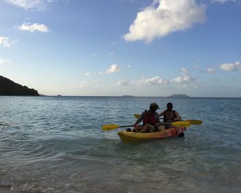 People in sea against sky