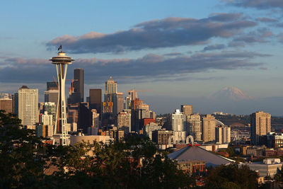 Buildings in city against cloudy sky