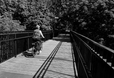 Man riding bicycle on footbridge