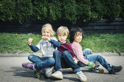 Full length portrait of friends sitting outdoors