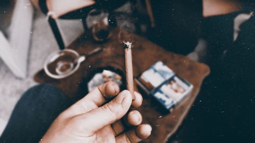 Close-up of person hand holding cigarette