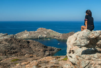 Man looking at sea against blue sky