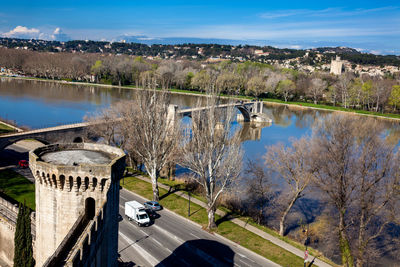 Bridge over canal by buildings in city against sky