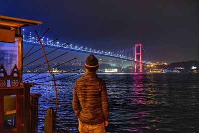 Rear view of man looking at suspension bridge