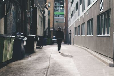 Man walking in empty alley 