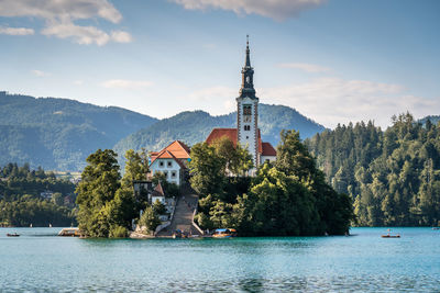 View of buildings by lake against sky