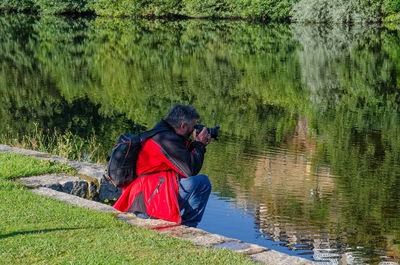 Rear view of people on lake amidst trees