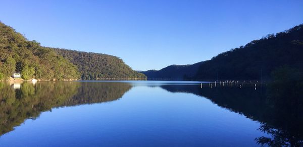 Scenic view of lake against clear blue sky