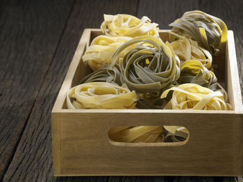 Directly above shot of tagliatelle pasta in crate on table