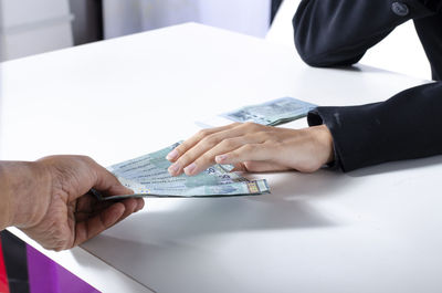 Midsection of people holding hands on table